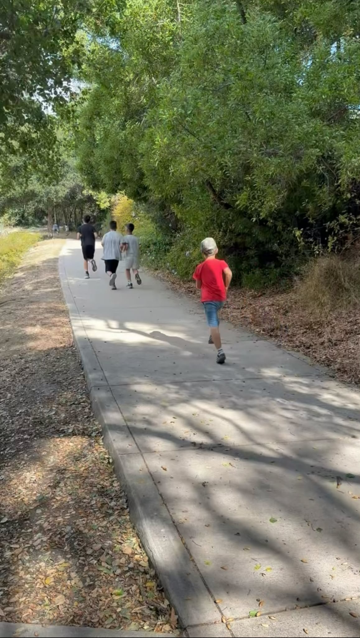 Club members jogging together along a tree-lined path